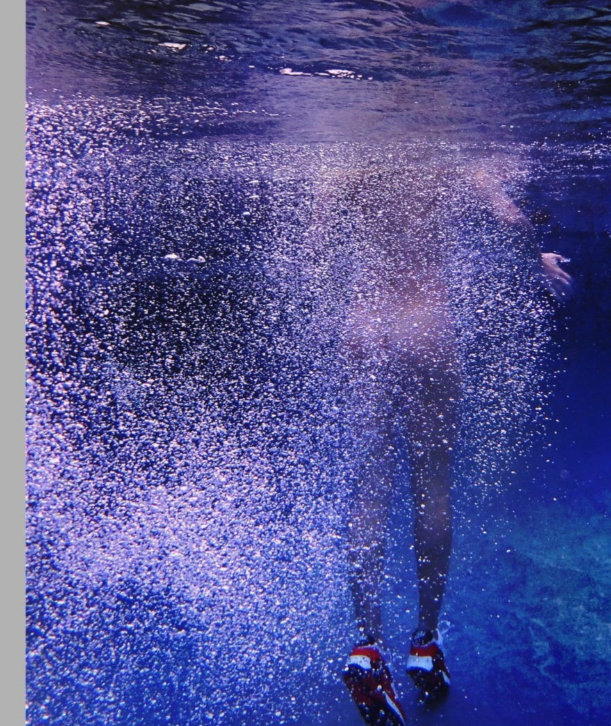 Trail of bubbles rising through blue water