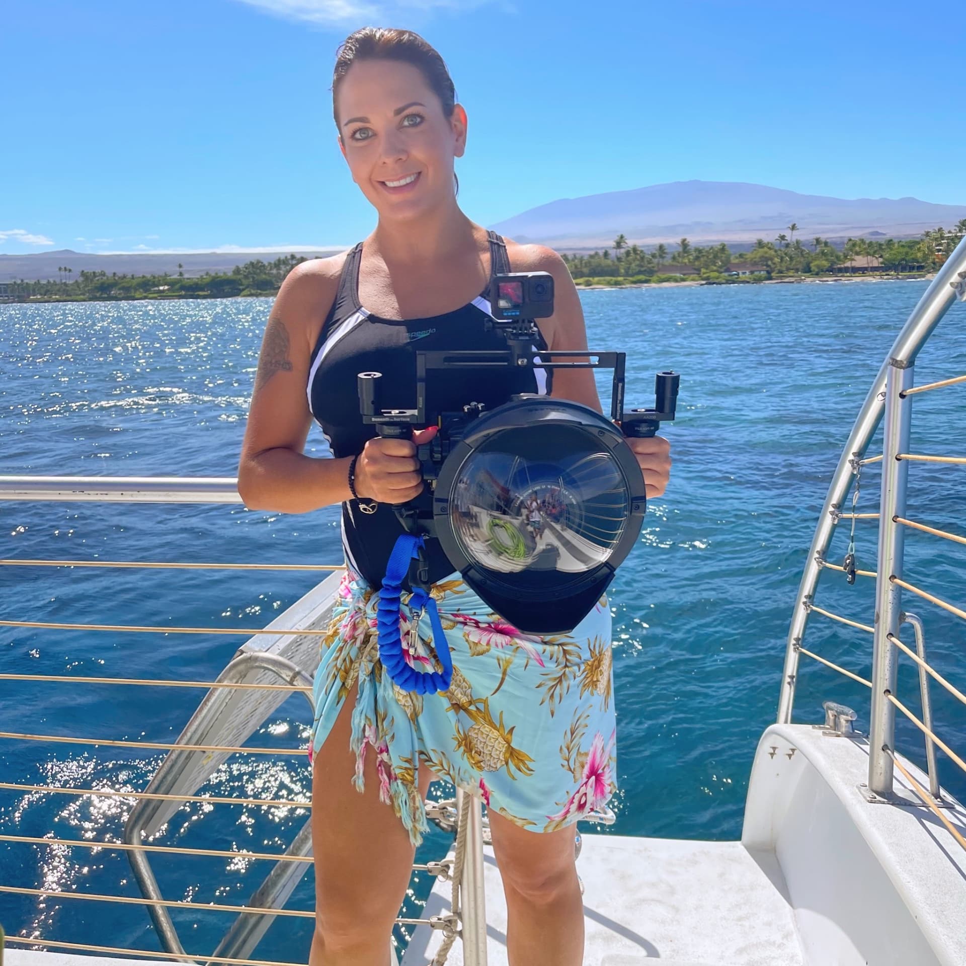 Mary Beteta on a boat holding an underwater camera housing